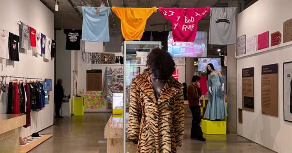 An exhibition from the Museum of Transology, a fur tiger stripped fur coat, posters, shirt and hoodies displayed.